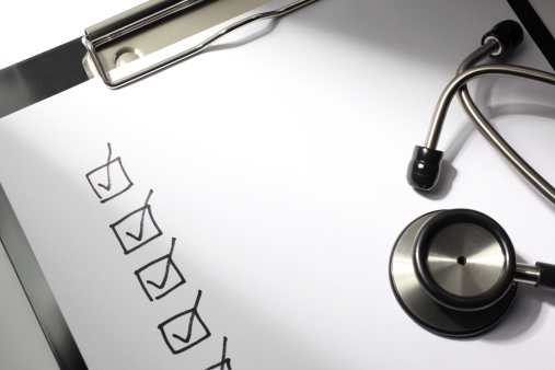 Healthcare concept. Check boxes drawn on a doctor's clipboard with stethoscope.