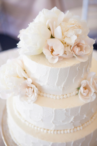 Beautiful white iced wedding cake with flowers.