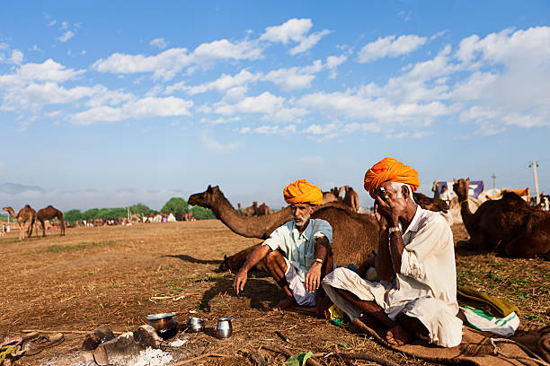 インドの男性喫煙中にはプシュカルフェスティバルオブライツパイプ - india campfire desert camel ストックフォトと画像