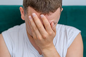 A man covering his face with his hand in shame