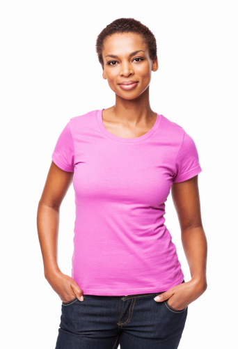 Portrait of a casual African American woman smiling with hands in pockets. Vertical shot. Isolated on white.