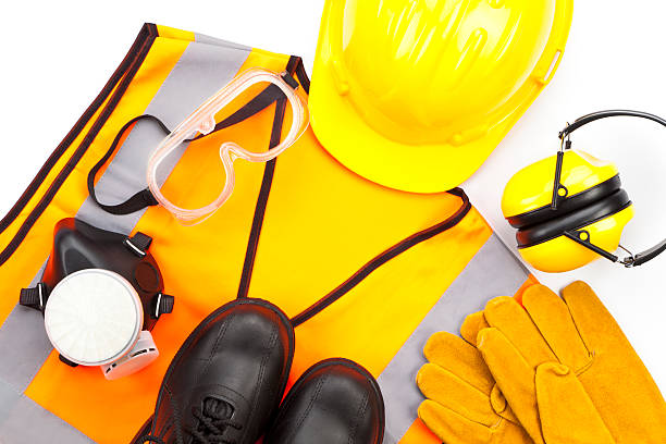 Personal protective workwear shoot from above on white background Industrial safety workwear shoot from above on white background. Includes hard hat, safety glasses, earmuff, gloves, respiratory mask, steel toe shoes and safety vest. The predominant color is yellow, a color mostly used in safety items. Studio image taken with Canon EOS 5D Mk II safety equipment stock pictures, royalty-free photos & images