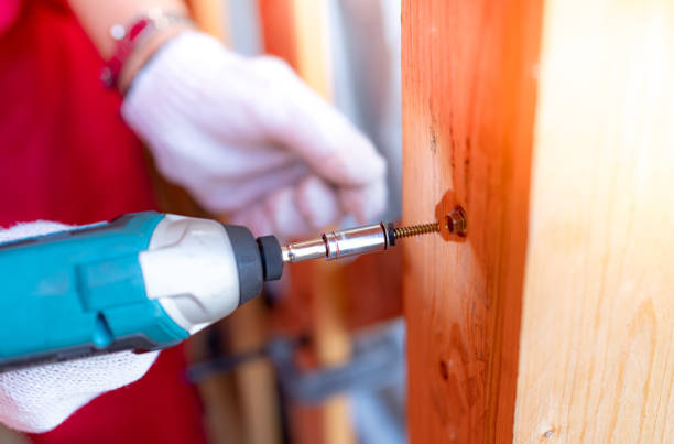 istock Carpenter and screwdriver hand tool. A skilled worker set to work drilling and installing wooden fixtures, using electric screwdriver to construct and repair parts of house with precision and care. 1712842212