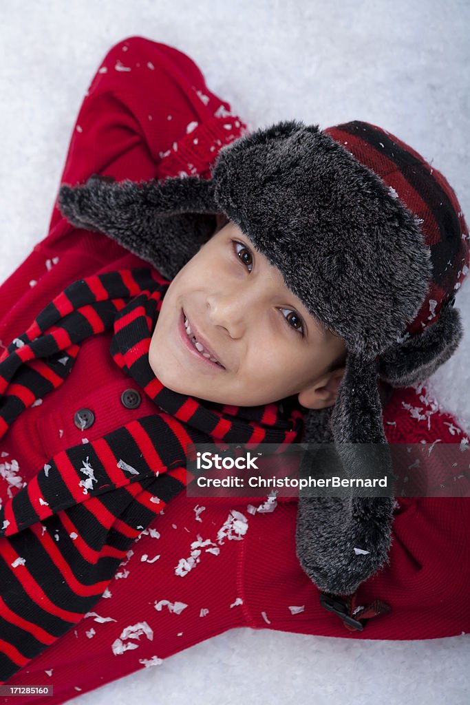 Young boy sentar en la nieve - Foto de stock de 8-9 años libre de derechos