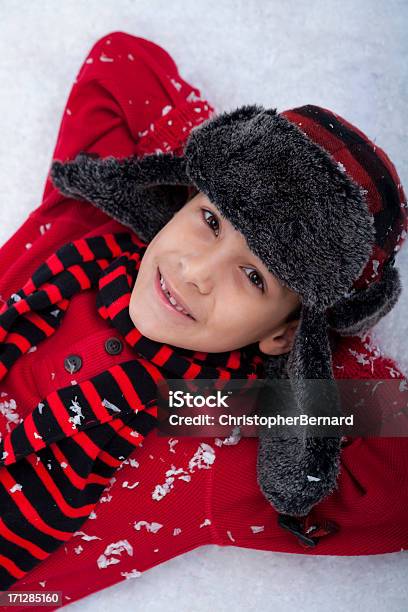 Young Boy Sentar En La Nieve Foto de stock y más banco de imágenes de 8-9 años - 8-9 años, Acostado, Acostado de espalda
