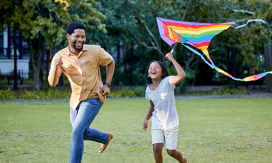 Happy girl and father playing a kite while running in a park, garden or lawn outdoor. Black family bonding, fun and happiness while laugh, smile and joy together with cute and adorable daughter