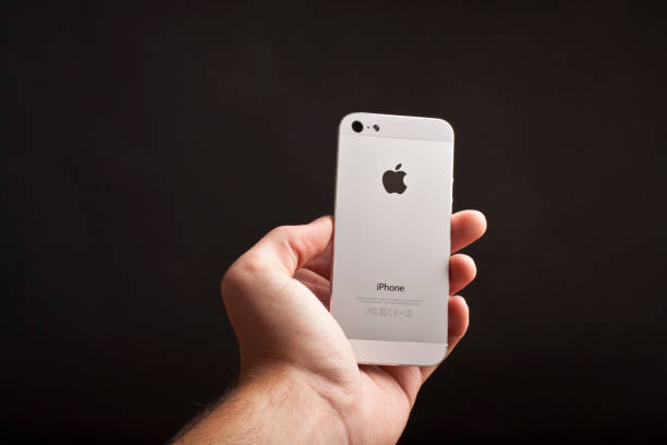 o iphone 5 com maçã sobre um fundo preto - iphone human hand iphone 5 blank - fotografias e filmes do acervo