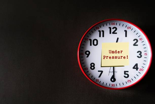 istock Clock on dark gray copy space background with note written UNDER PRESSURE! means dealing with time constraints which are often outside of control - difficulty task or having insufficient knowledge 1712854703