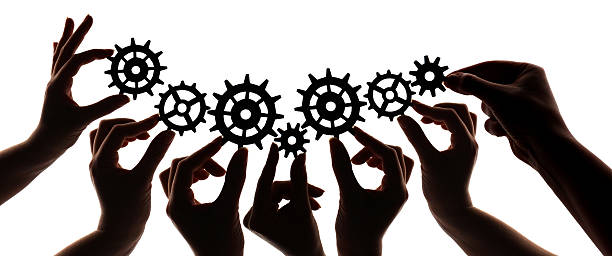 Silhouette of hands holding cogs and gears