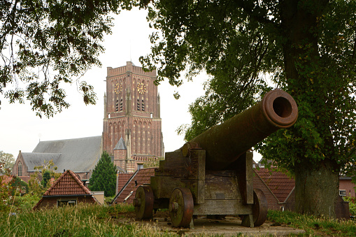 North Brabant: Woudrichem ,looking at on old cannon and in background the church tower. 
Woudrichem is a fortified village.