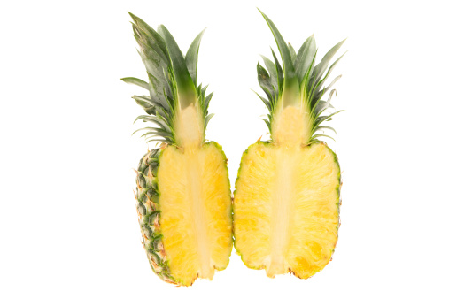 Fresh pineapple cut in half - studio shot with a white background