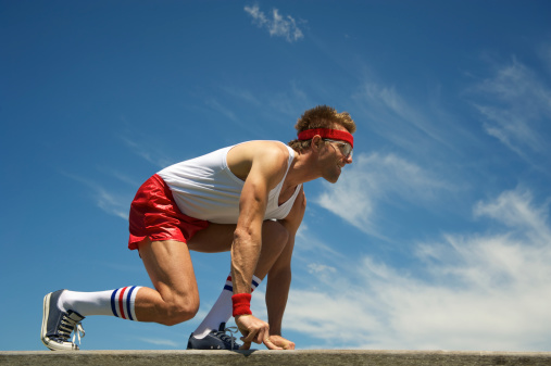 Nerd athlete gets ready at the starting blocks to start a sprint