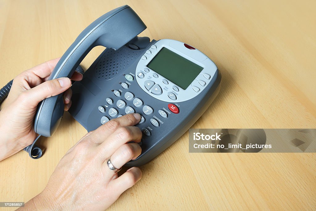 business phone Woman is taking the telephone receiver and dialing a number.business / office Adult Stock Photo