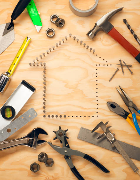 Construction and Home Building This is an overhead photo of nails in the shape of a home surrounded by a variety of construction tools. There is space for copy in the middle of the house shape.Click on the links below to view lightboxes. work tool nail wood construction stock pictures, royalty-free photos & images