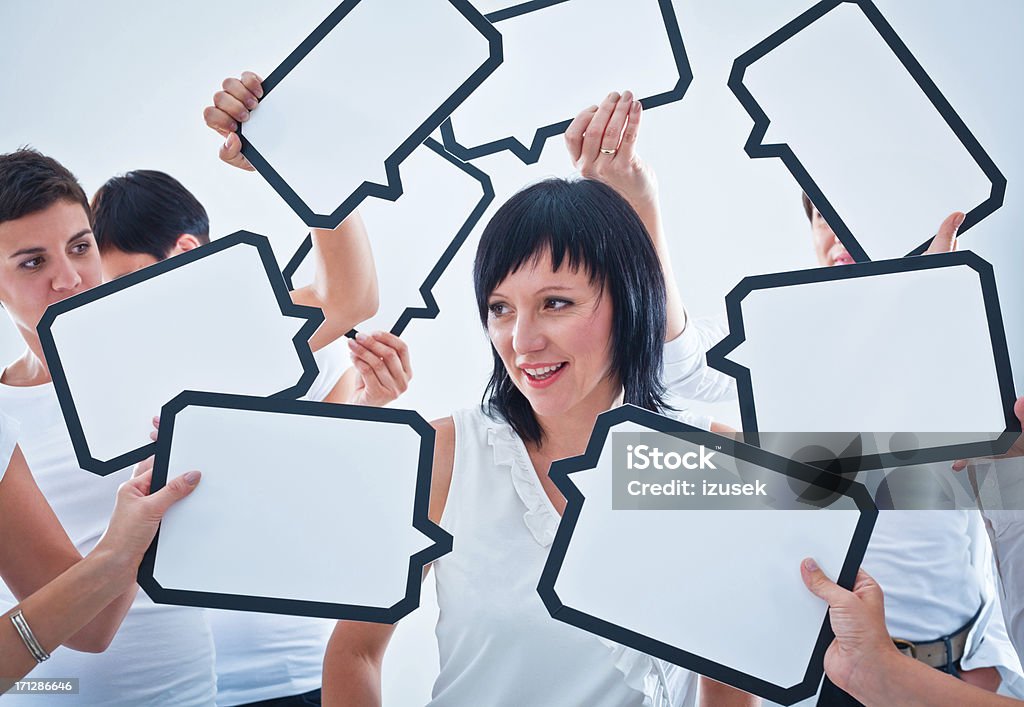 Looking for an idea Smiling woman surrounded by many speech bubbles with copyspace. Confusion Stock Photo