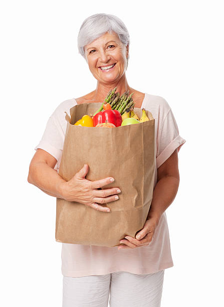 anziani donna con il sacchetto di generi alimentari-isolato - senior adult aging process supermarket shopping foto e immagini stock