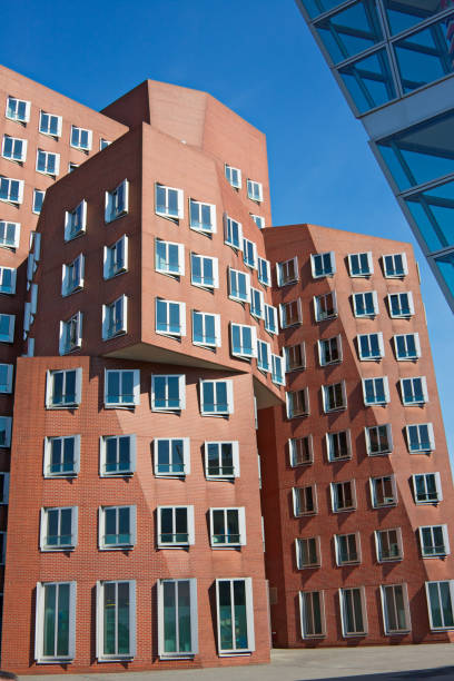 Frank O. Gehry's Neuer Zollhof buildings at MedienHafen, Dusseldorf "Dusseldorf, Germany - May 14, 2012: Famous distorted buildings at Medienhafen designed by famous American architect Frank O. Gehry's. The building complex consists of three separate buildings and was completed in 1998" frank gehry building stock pictures, royalty-free photos & images