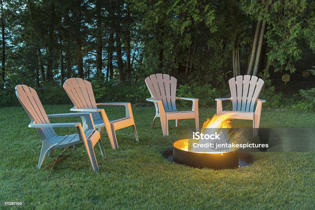 Sedie intorno a un fuoco di accampamento - Foto stock royalty-free di Focolare all'aperto