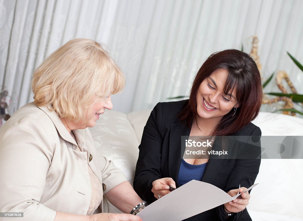 Consultor com um cliente para revisar documentos - Foto de stock de Cliente royalty-free