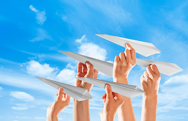 istock Five hands holding paper airplanes against blue sky 171287867