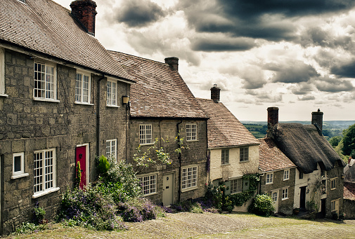 A row of houses on Gold Hill, an old street in Shaftesbury England.  Taken on a cloudy/rainy day and processed to enhance the dramatic tones.