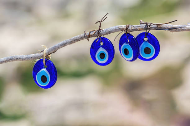 istock Traditional Turkish amulet Evil Eye or blue eye (Nazar boncugu) on tree brunch. Traditional Turkish amulet and souvenir. Close up, defocused background, copy space. Cappadocia, Turkiye (Turkey) 1712885411