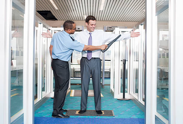 Airport Security Check Point "Airport security checkpoint, a business man is getting the metal detector wand." metal detector security stock pictures, royalty-free photos & images