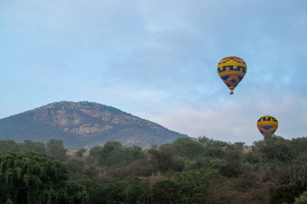 istock Two hot air balloons drift over a hilltop 1712889776