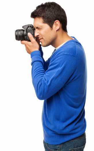 Side view of male photographer using a DSLR camera. Vertical shot. Isolated on white.