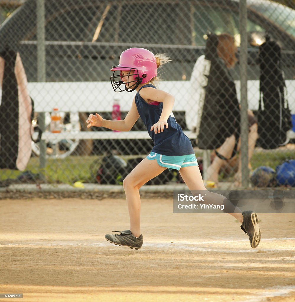 Молодая девушка бежит игры в софтбол игры - Стоковые фото Софтбол - спорт роялти-фри