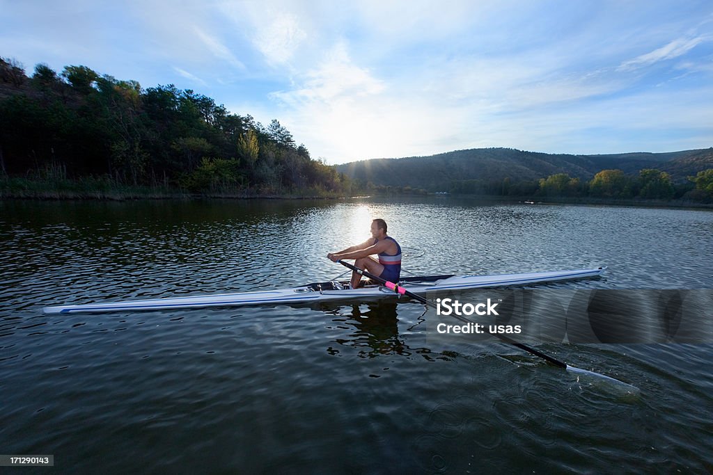 Canottaggio uomo adulto canottaggio sculling barca sul lago - Foto stock royalty-free di Barca da canottaggio