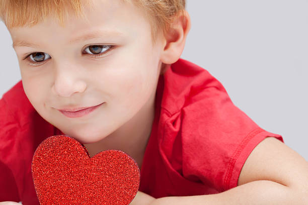 Have a Heart Portrait of a little boy holding a heart shape. cute boy show love symbol hand stock pictures, royalty-free photos & images