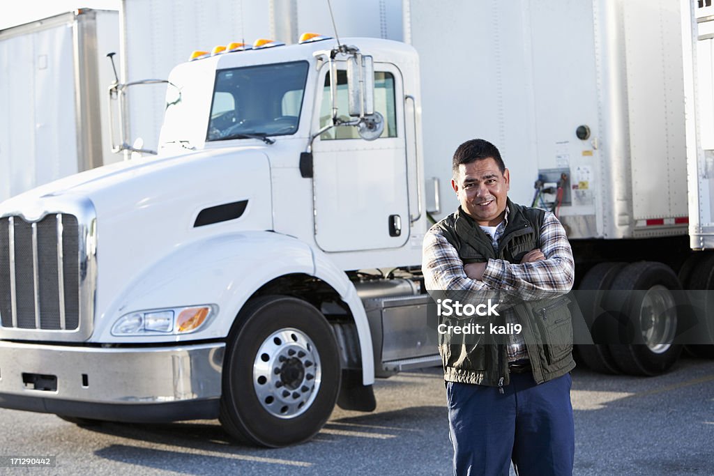 Hispanic truck driver Hispanic truck driver (40s) standing in front of semi-truck. Truck Driver Stock Photo