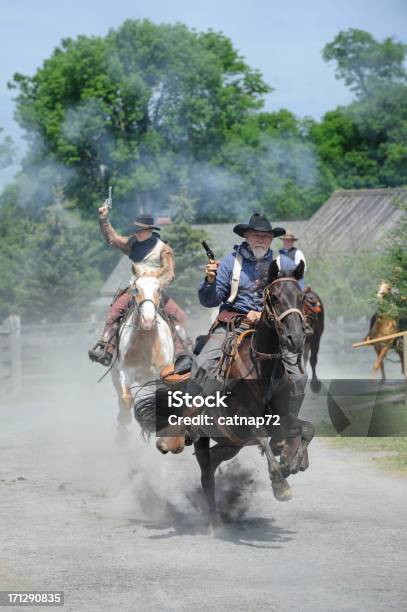 Foto de Cowboys Equitação Difícil E Rápida Pela Cidade Armas De Fogo Incandescente e mais fotos de stock de Vaqueiro