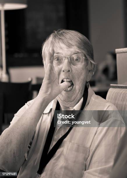 Senior Mujer Haciendo Funny Face In A Cafe Foto de stock y más banco de imágenes de 70-79 años - 70-79 años, Adulto, Alzar la mano