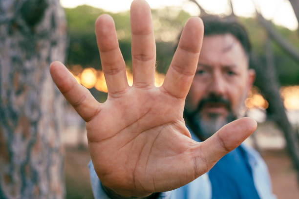 istock One man put his hand in front of the camera to stop. Serious expression. Against climate change and hope for the future. Activist block gesture. War breakout. Nature forest in background environment 1712915533