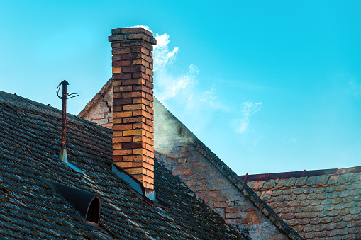 Smoke from the chimney of an old house with copy space