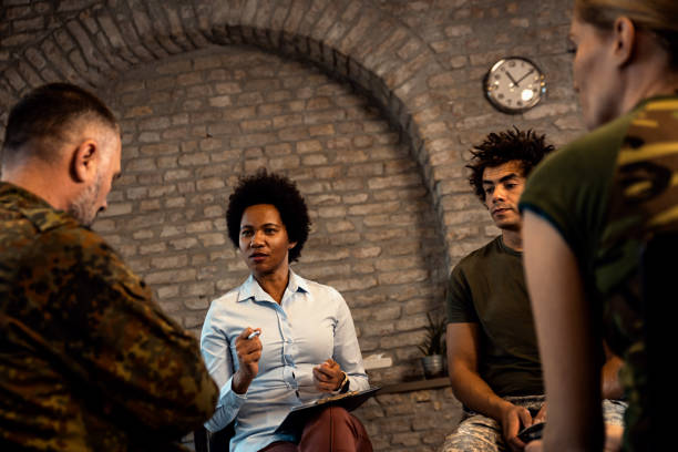 istock Female psychologist talking to group of diverse veterans during PTSD support group. 1712920046