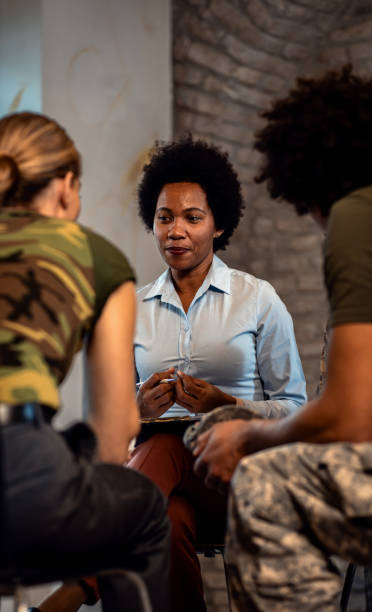 istock Female psychologist talking to group of diverse veterans during PTSD support group. 1712920062