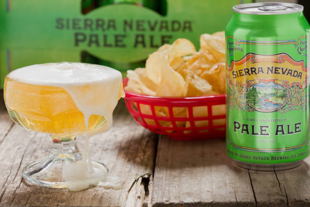 Sierra Nevada Pale Ale "Chico, California, USA - June 11, 2012 : A close up of a green 12Fl OZ can of Sierra Nevada Pale Ale, a sampler glass goblet of beer, chips in a red basket and in the background is a cardboard case containing 12 12Fl OZ cans of Sierra Nevada Pale Ale." chico california photos stock pictures, royalty-free photos & images