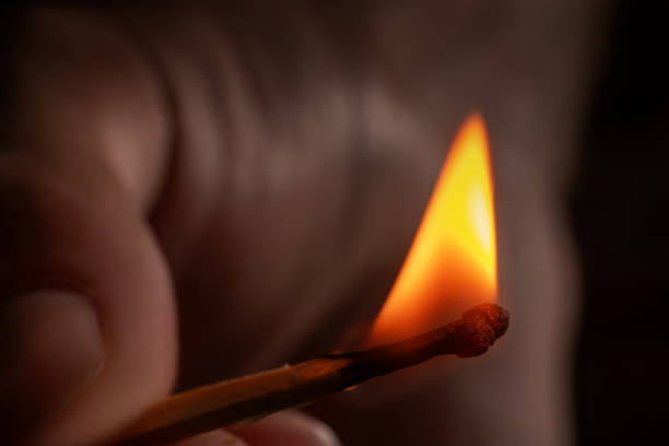 istock Hand holding burning match stick. Photo on a black background 1712921978