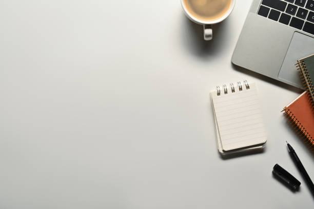 istock Blank notepad, laptop, coffee cup and pen on white background. Flat lay, top view with copy space 1712923263