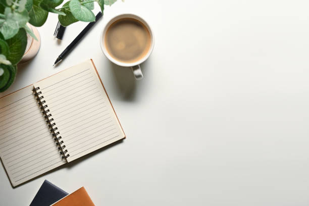 istock Blank spiral notebook, pen, coffee cup and potted plant on white background. Top view with copy space 1712923268