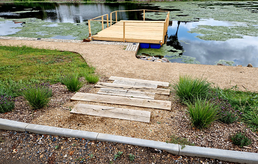 steps from the beams on the terrace by the shore. lined with decorative beds and avenues of linden trees. park improvements near the water surface, a bike path and mooring posts for fishermen's boat