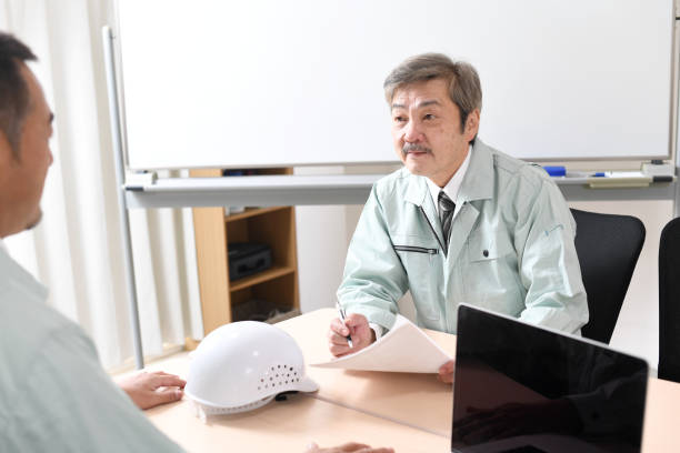 istock Middle-aged Asian man wearing work clothes having a conversation 1712926707