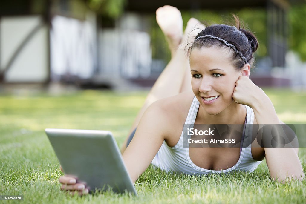 Молодая женщина, чтение что-то на цифровой планшет в парке - Стоковые фото 20-29 лет роялти-фри