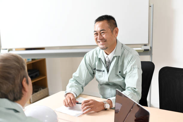 istock Middle-aged Asian man wearing work clothes having a conversation 1712927110
