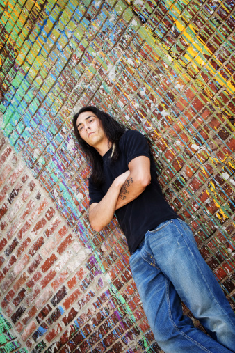 Young man leaning against a colorful backdrop. More of this series...