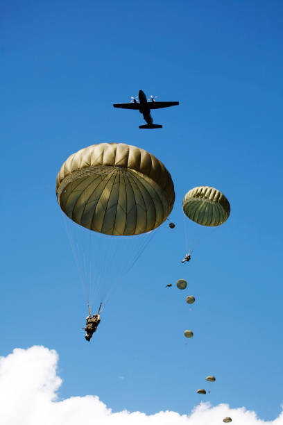 ATTENTION FOR INSPECTOR: This is a composite photo and the date of model releases are different from the date of image. Please consider this. Paratroopers jumping from the plane and military helicopters leave behind soldiers for a night mission.