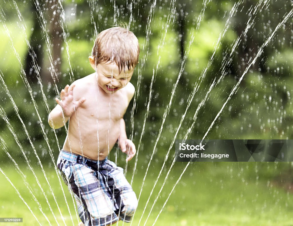 Menino brincando em chuveiro de incêndio (sprinkler) - Foto de stock de Criança royalty-free